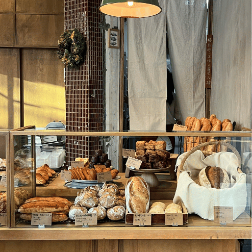 Vitrina de panadería con variedad de panes y pastelería.